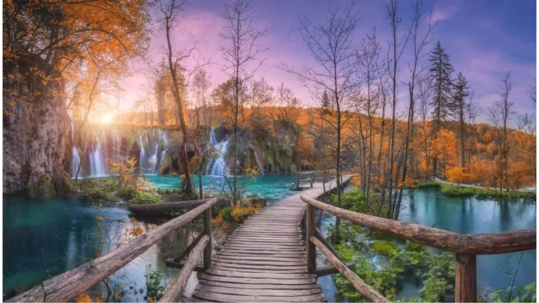 Vodopad i drvena staza u narančastom šumarku u Plitvičkim jezerima